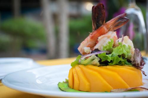 a piece of food on a white plate on a table at Kena Beach Hotel in Matemwe