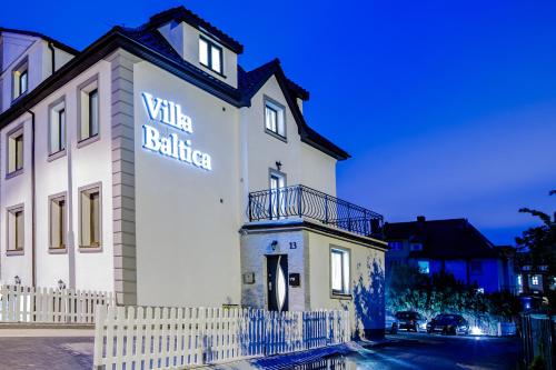 een wit gebouw met een bord aan de zijkant bij Villa Baltica in Świnoujście