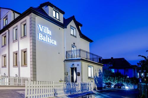 biały budynek z napisem na boku w obiekcie Villa Baltica w Świnoujściu