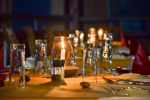 a table with candles and glasses on a table at Kena Beach Hotel in Matemwe