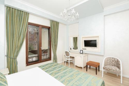 a bedroom with two beds and a desk and a television at Oxford hotel in Tirana