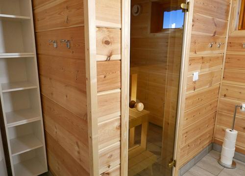 a walk in shower with wooden walls and a wooden at Mikkelvik Brygge in Mikkelvika