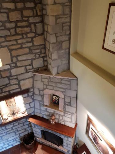 a fireplace in a room with a stone wall at Pallas Casa in Panagía