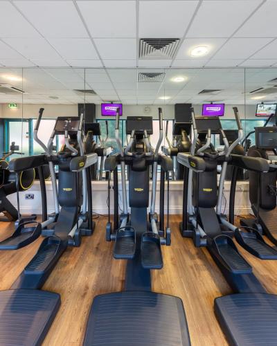 a gym with rows of tread machines at Novotel Cardiff Centre in Cardiff