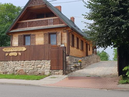 a wooden house with a fence in front of it at Aleksandrówka - Domek Anastazja in Trześcianka