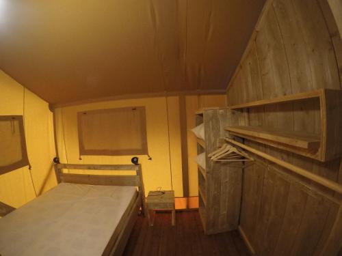 Habitación pequeña con cama y estanterías de madera en Càmping Parc Gualba en gualba de Dalt