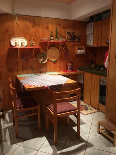 a kitchen with a table and two chairs and a counter at Residence Sole Alto, Località Marilleva 1400 in Marilleva