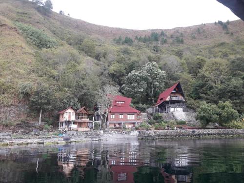 a group of houses on the shore of a lake at Pondok Berata Dapdap in Balige