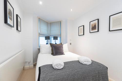 ロンドンにあるLovely 2 bedroom flat in Chelsea, sleeps 4のベッドルーム1室(タオル付)