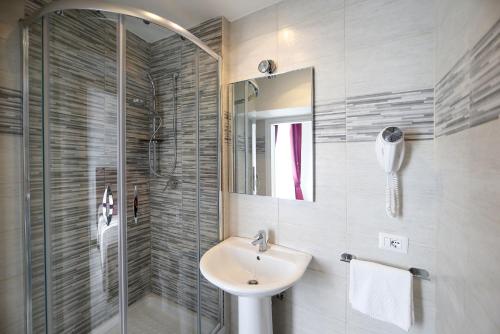 a bathroom with a sink and a glass shower at 47 Steps in Rome