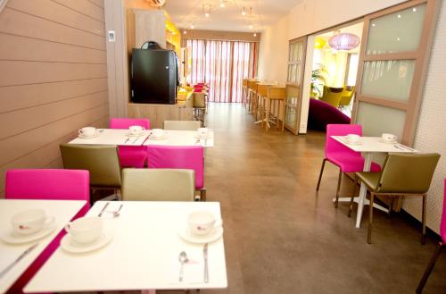 Hôtel Anne De Bretagne في رين: غرفة طعام مع طاولات وكراسي وتلفزيون