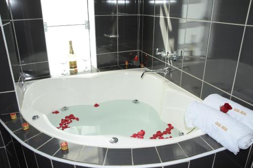 El baño incluye bañera con flores rojas. en Casa Real Hoteles, en Cusco