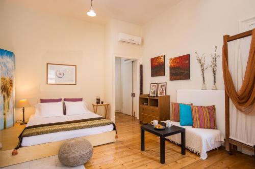 Kamara House في مدينة كورفو: غرفة نوم بسرير وطاولة واريكة