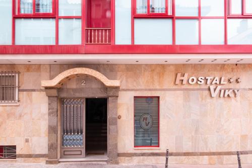 un edificio con un signo de vitamina de anfitriona en él en Hostal Viky en Madrid