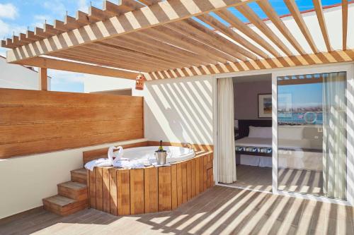 Aranwa Paracas Resort & Spa في باراكاس: حمام مع حوض استحمام وغرفة نوم