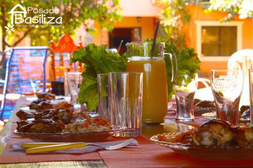 恩卡納西翁的住宿－Posada Basiliza, Encarnación PY，餐桌,盘子上放着食物,还有一罐橙汁