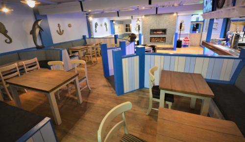 a restaurant with wooden tables and chairs and a counter at Causeway Coast Apartment in Ballycastle