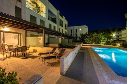 a patio with a pool and a table and chairs at Duplex La Nau By homevillas360 in Port de Pollensa