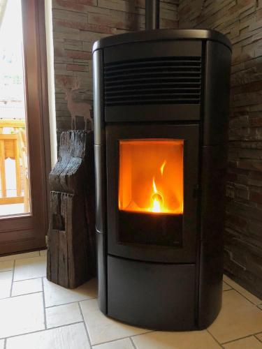 a fireplace with a fire in it in a room at La Chambre des Rêves in Aosta