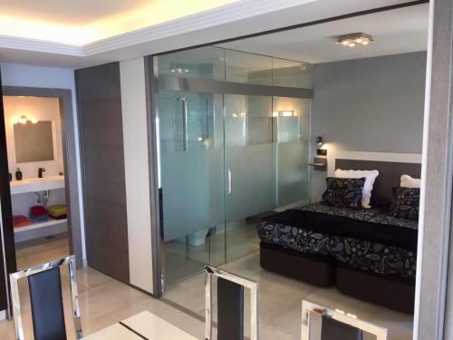 Una habitación con ducha de cristal y una cama dentro. en Deluxe Supreme, en Málaga