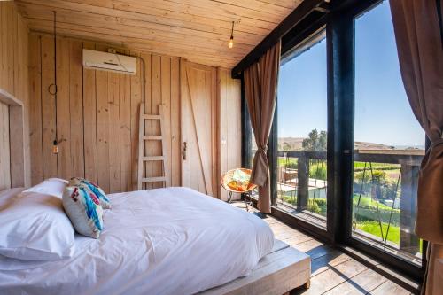 sypialnia z łóżkiem oraz balkon z dużymi oknami w obiekcie Manulodge Matanzas w mieście Matanzas