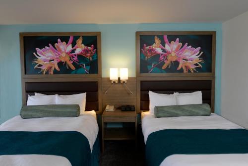 a hotel room with two beds and two paintings at Rod 'N' Reel Resort in Chesapeake Beach