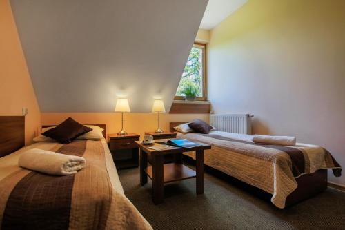 una habitación de hotel con dos camas y una mesa en Pensjonat Arnika, en Zakopane