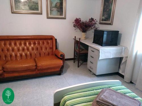 ein Wohnzimmer mit einem Sofa und einem TV in der Unterkunft B&B La Magnolia in Creazzo