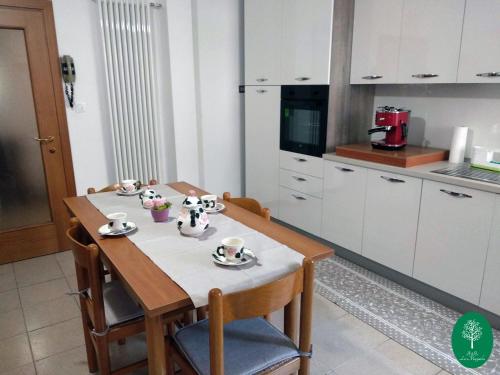 uma cozinha com uma mesa com copos e pires em B&B La Magnolia em Creazzo