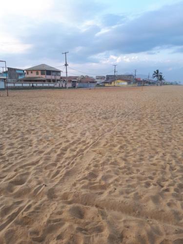 una playa de arena con huellas en la arena en Casa em Unamar,Cabo Frio,à 200m da praia,em condomínio com segurança 24 hs, en Cabo Frío