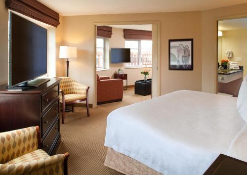 a hotel room with a bed, tv and a chair at Silver Cloud Hotel - Seattle Broadway in Seattle