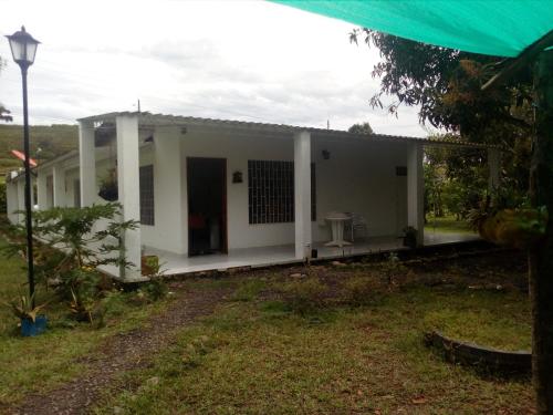 a small white house with a porch at Finca la Miradita in Cumaral