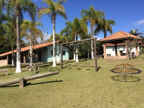 a playground in front of a building with palm trees at Pousada Recanto dos Maximianos in Jarinu