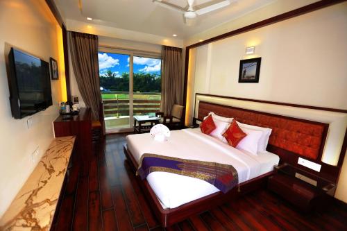 a bedroom with a large bed and a large window at Comfort Inn Benares in Varanasi