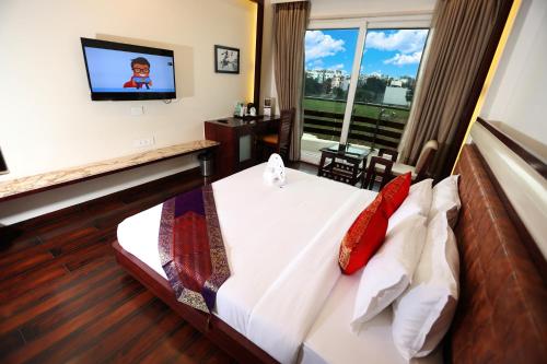a hotel room with a bed and a tv at Comfort Inn Benares in Varanasi