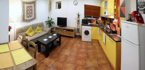 a living room with a couch and a kitchen at Alojamiento Mercado de Abastos in Úbeda