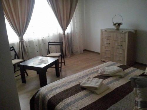 a bedroom with a bed and a table and a dresser at Laguna Verde in Crivina
