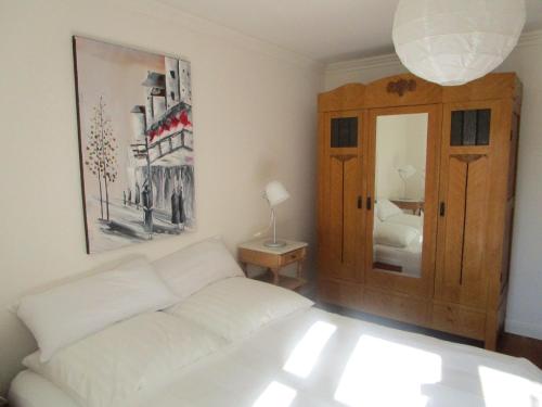 ein Wohnzimmer mit einem weißen Sofa und einem Spiegel in der Unterkunft Ferienwohnungen Hebbel in Husum