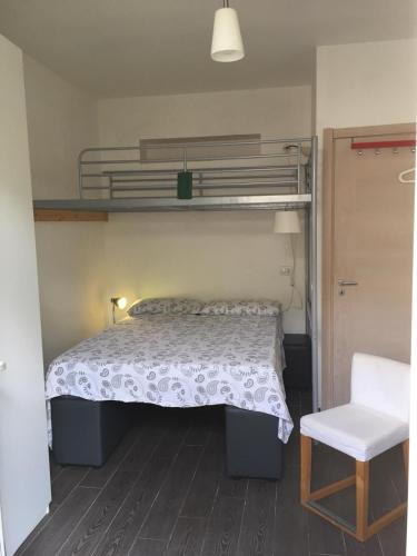 a bedroom with a bunk bed and a chair at lo zahir in Marina di Ragusa