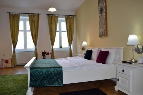 um quarto com uma grande cama branca e janelas em Casa Krone - Piața Sfatului em Braşov