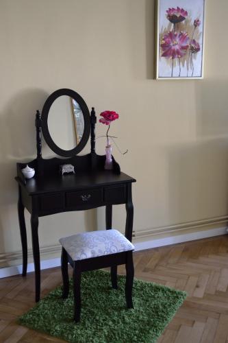 a black vanity with a mirror and a stool and a chair at Casa Krone - Piața Sfatului in Braşov