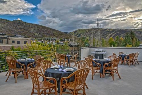 a dining area with tables, chairs, and umbrellas at Park City Hostel in Park City