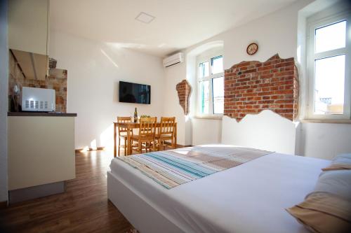 um quarto com uma cama e uma cozinha com uma mesa em Lighthouse Rijeka em Rijeka