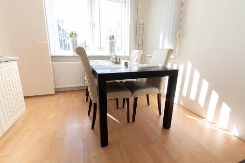 a black dining room table with white chairs in a room at Appartement Schin op Geul in Schin op Geul