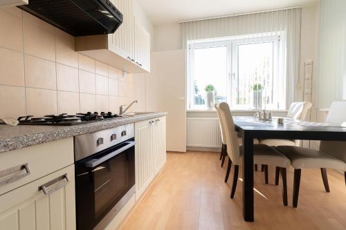 a kitchen with a table and a dining room at Appartement Schin op Geul in Schin op Geul