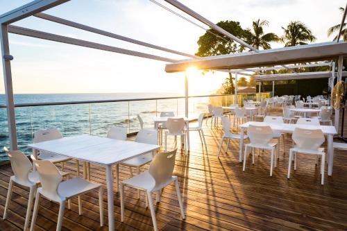 a restaurant with white tables and chairs on a deck at Acantilados in La Libertad