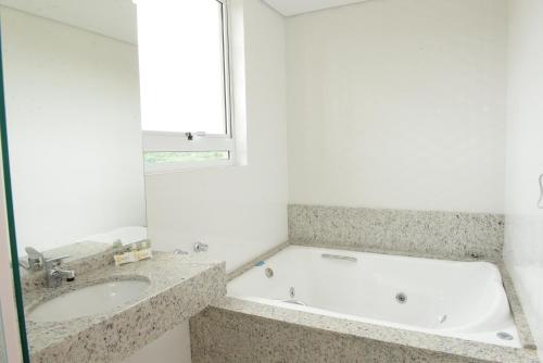 La salle de bains est pourvue d'une baignoire et d'un lavabo. dans l'établissement Hotel Solar do Parque, à Tabapira