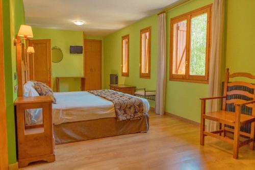 パンティコサにあるHotel Sabocosの緑の壁のベッドルーム1室、ベッド1台、椅子1脚が備わります。