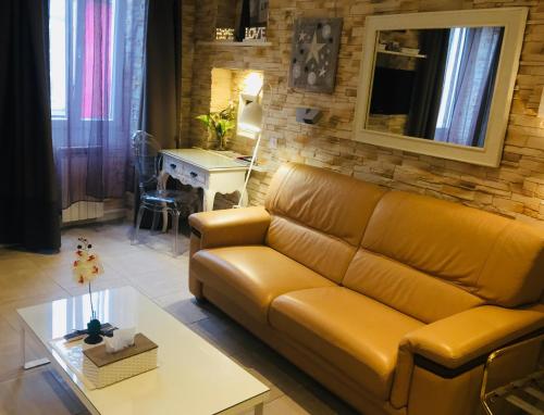 a living room with a couch and a table at Appart' Spa et Sauna Privatif Au Cœur De Beaune in Beaune