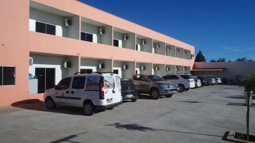 un estacionamiento con autos estacionados frente a un edificio en Pousada Aerogrill en Juazeiro do Norte